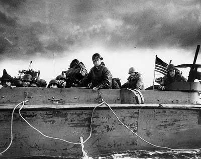 Troops and crewmen aboard a LCVP (Landing Craft, Vehicle, Personnel) as it approaches a Normandy beach, June 6, 1944.